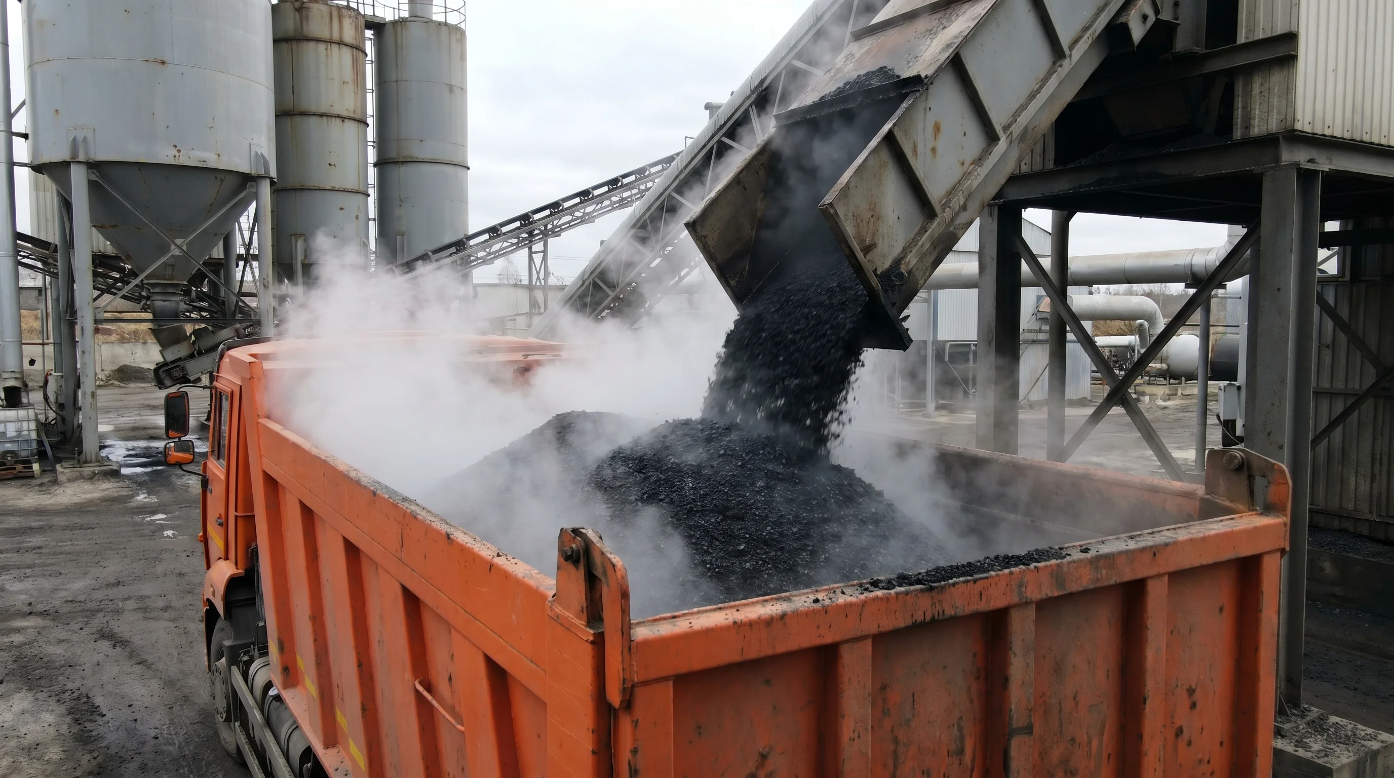 Dump truck being loaded with hot mix asphalt at an asphalt plant