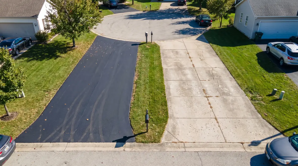 Adjacent asphalt and concrete driveways side by side